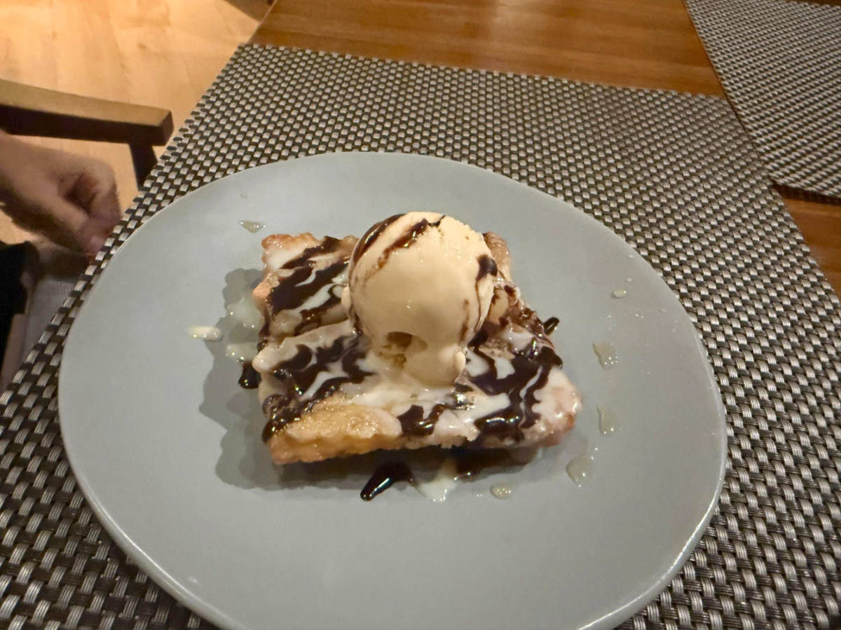 A plate of dessert topped with a scoop of an ice cream