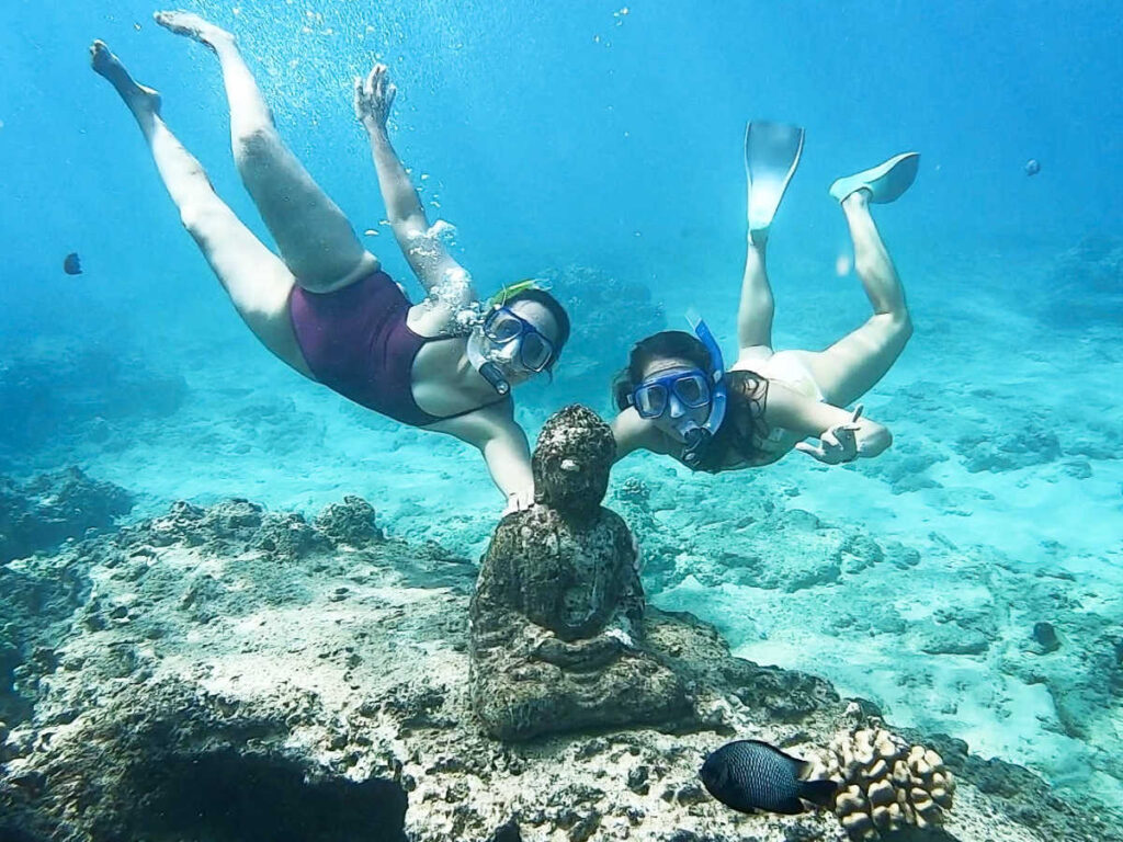 The author Rebecca Parsons and her friend diving at the Buddha statue under the water