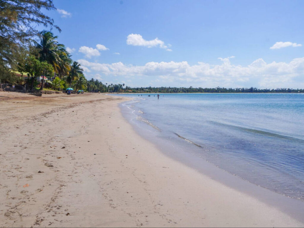View of the vast white sand beach surrounded by greenery at the West Side of Dorado Beach