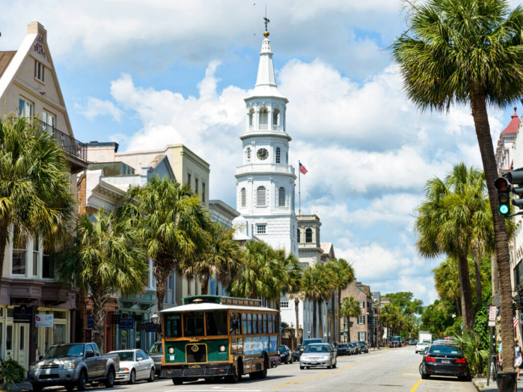 A trolley passing the St Michaels Church along the Downtown Charleston
