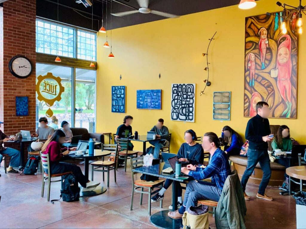 People enjoying coffee while working on their laptop at Caffe Luce