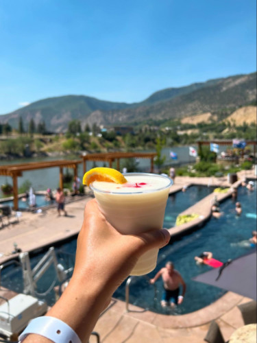 Holding a beverage on the poolside at Iron Mountain Hot Springs