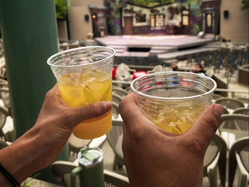 Two hand holding drinks at the outdoor Idaho Shakespeare Festival
