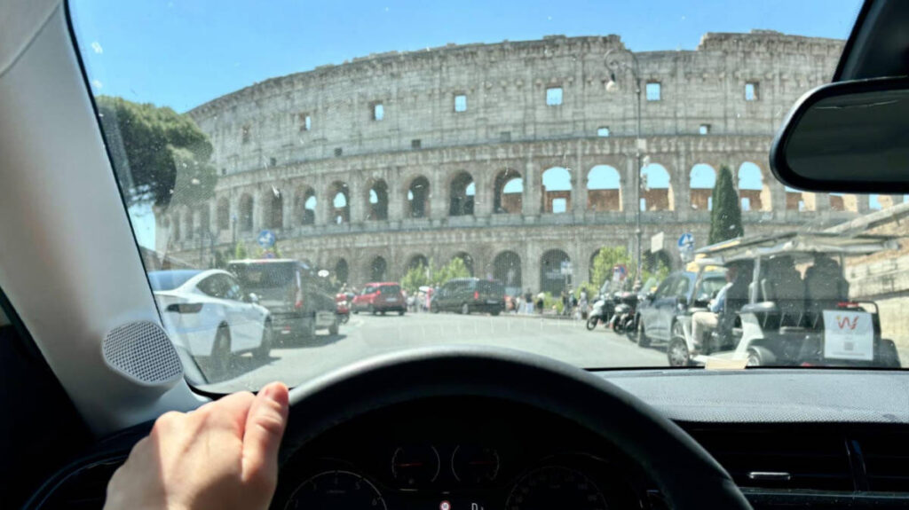 The author driving with a view of the Colosseum