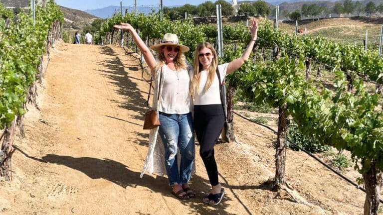The author Jess Levy and her friend posing in the middle of a vineyard
