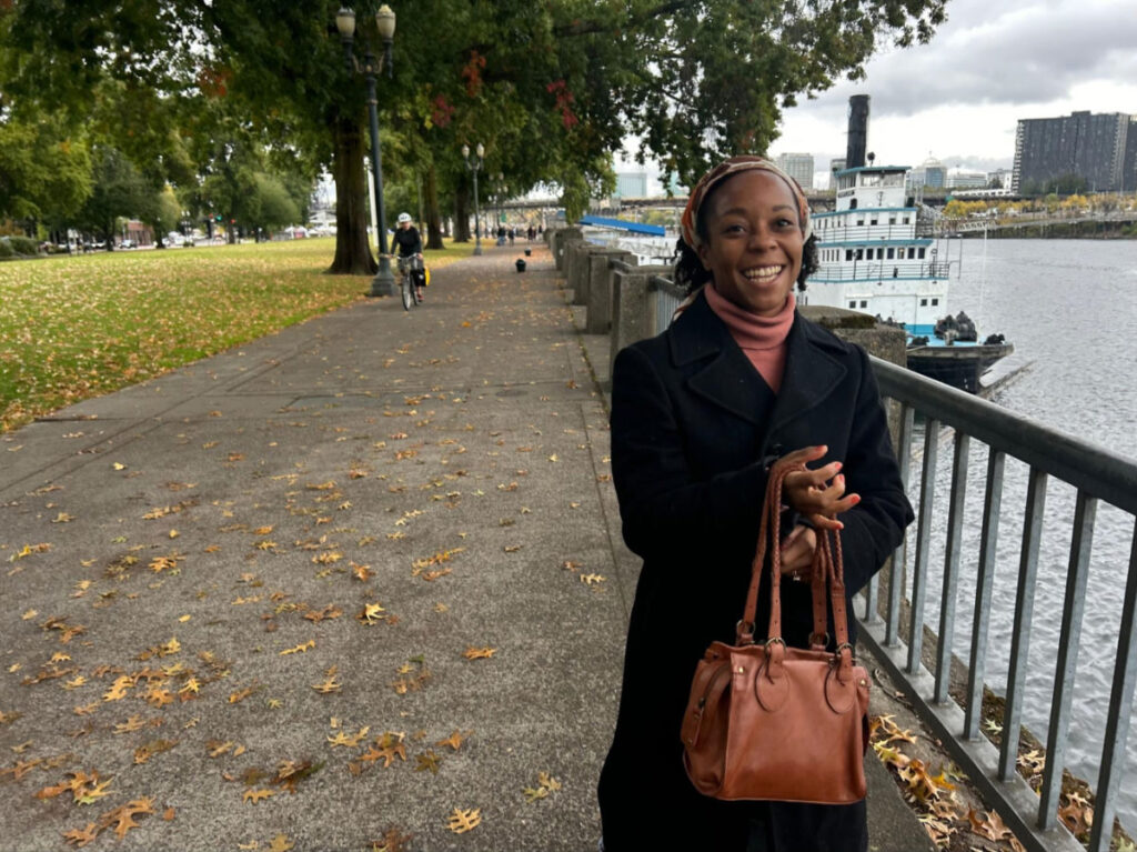 Travel Lemming editor Chelsea smiling brightly at Tom McCall Waterfront Park in Portland
