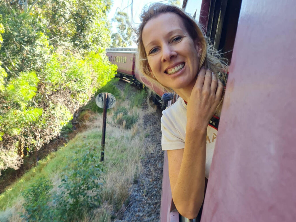 The author Elise Kirsten, enjoying the wind while on a train ride