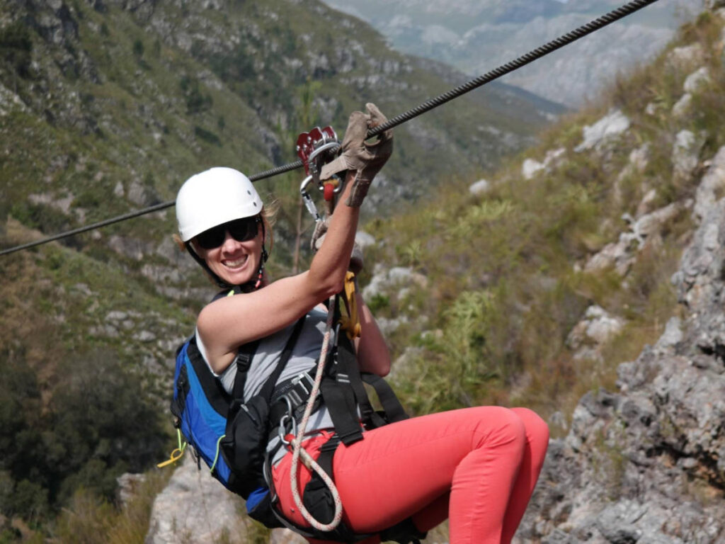 The author Elise Kirsten, smiling for a photo on a zipline