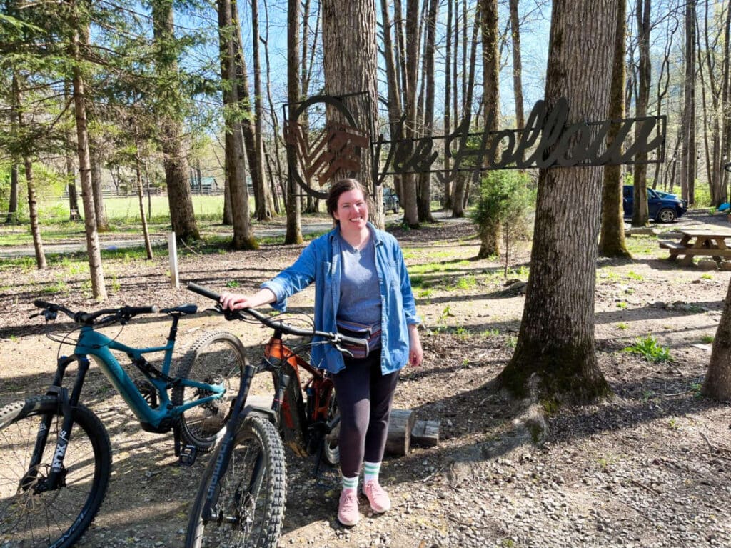 Travel Lemming Editor Elizabeth Demolat, posing for a photo while holding a bicycle at the Vee Hollow