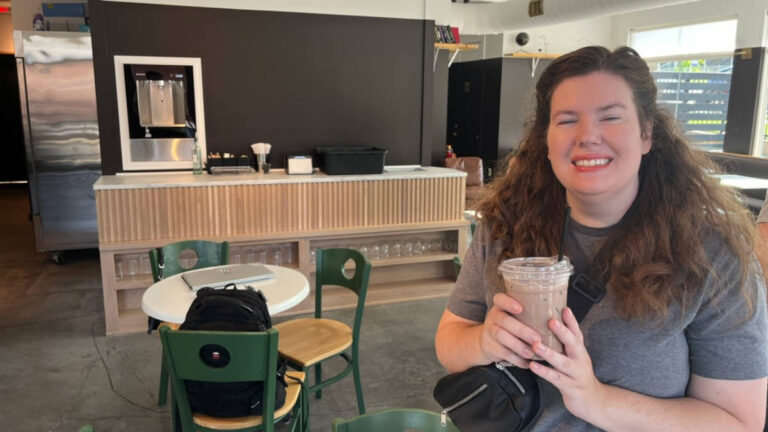 The author Elizabeth Demolat, holding a drink at Momento Specialty Coffee