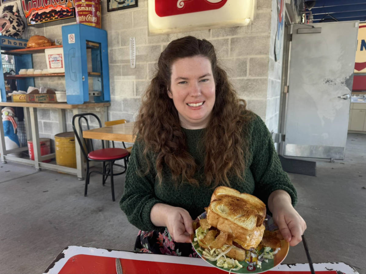 The author Elizabeth Demolat, holding a plate with a huge sandwich from Turkey and the Wolf