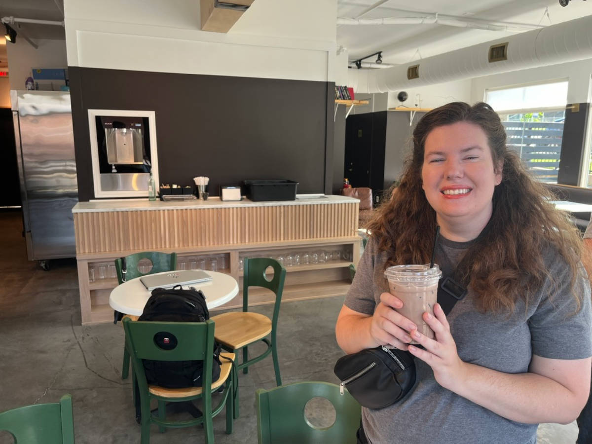 The author Elizabeth Demolat, holding a drink at Momento Specialty Coffee