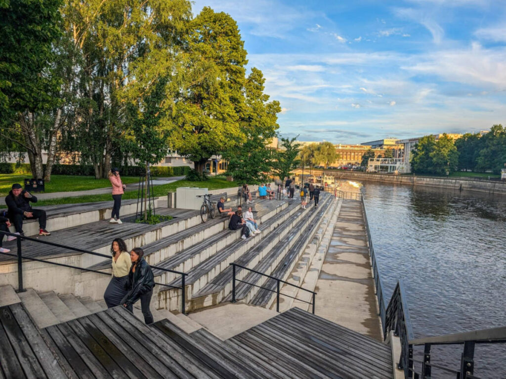 People chilling along the Emajõgi river promenade at sunset