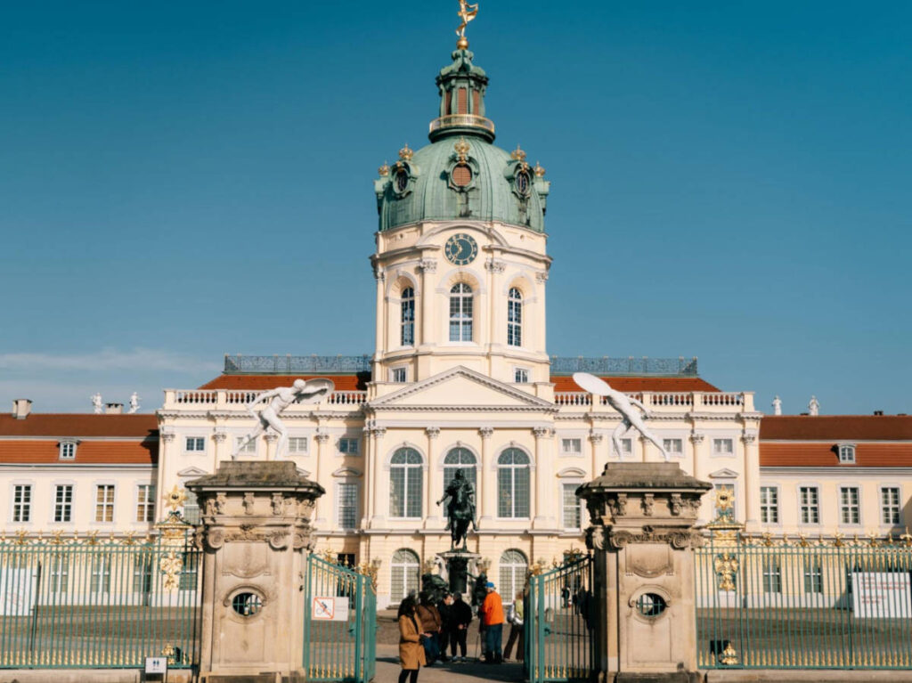 The tourists at the entrance and the grand facade of Schloss Charlottenburg