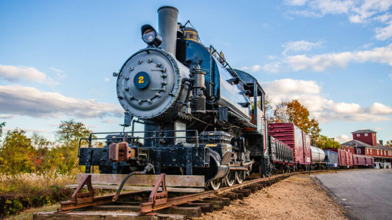 The Essex Steam Train on the tracks under a clear blue sky