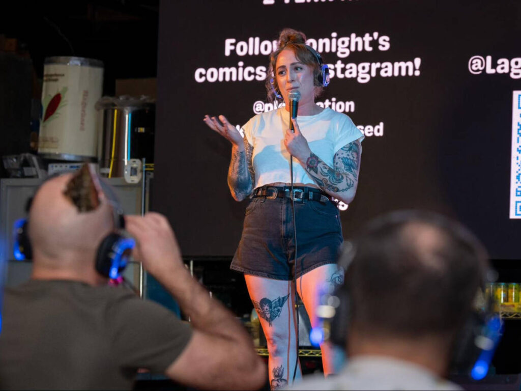 A woman on the stage of Lagers & Laughs