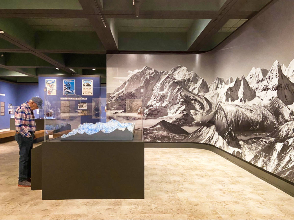 An old man looking the Everest mountain climbing exhibit at the Santa Ana museum