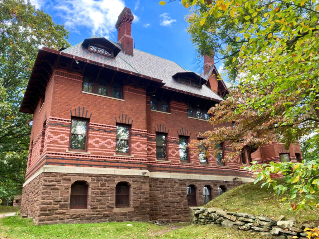 View of the brick walled exterior of Mark Twain House with lush trees around