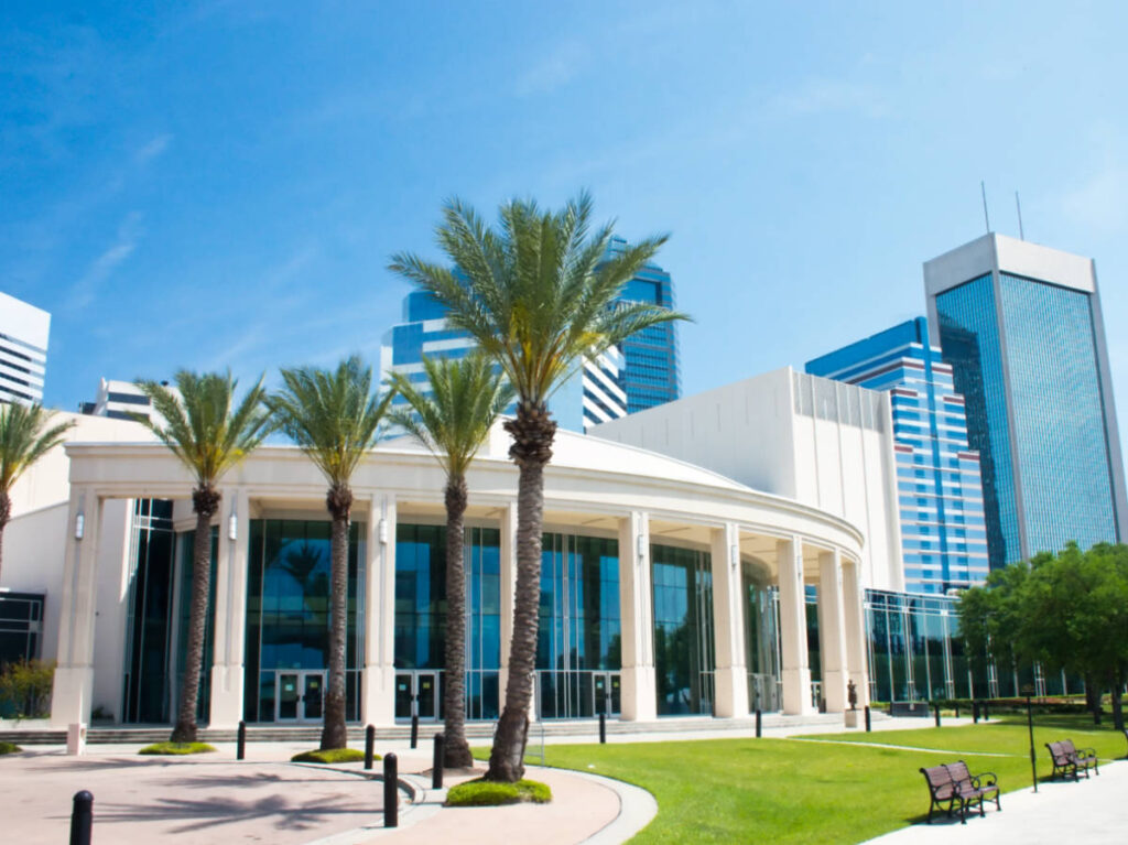 Exterior view of the Jacksonville Center for Performing Arts with the tall buildings in the background