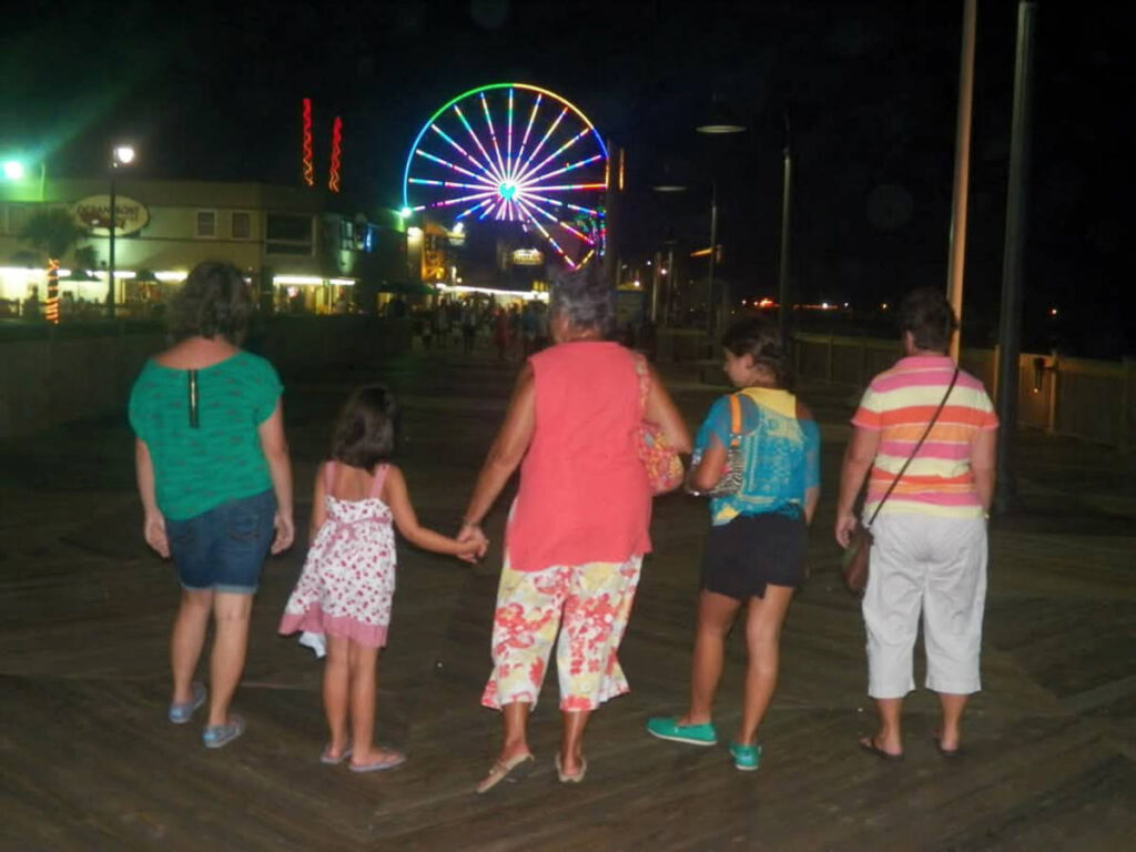 A family walking together on the Boardwalk at night