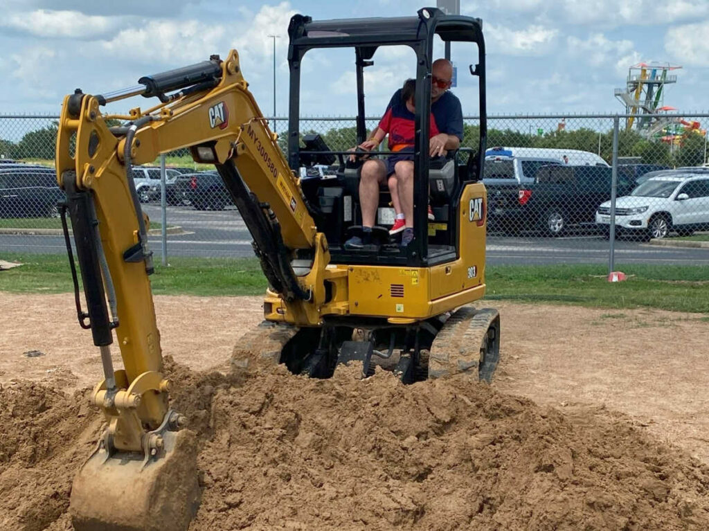 A father and son driving an excavator