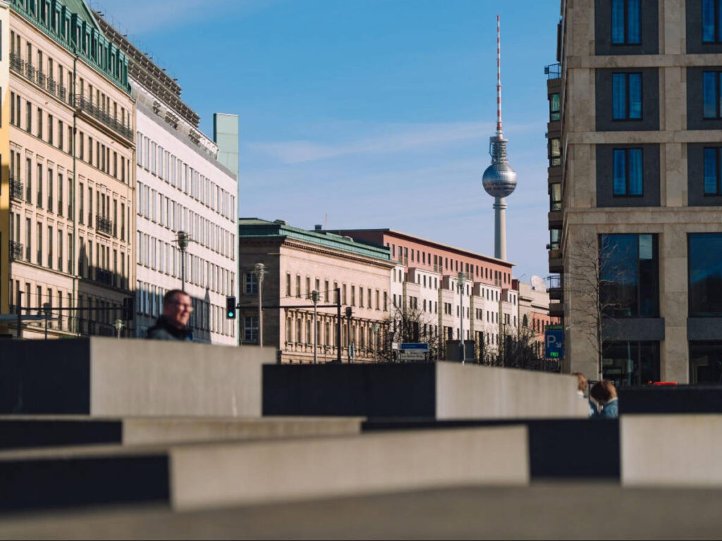 A man sitting with the views of Fernsehturm and Holocaust Monument