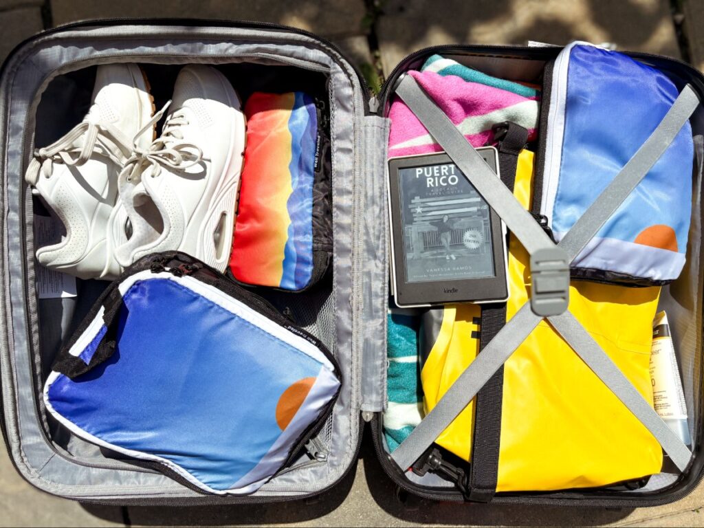 A carry-on luggage filled with packing cubes and other travel essentials