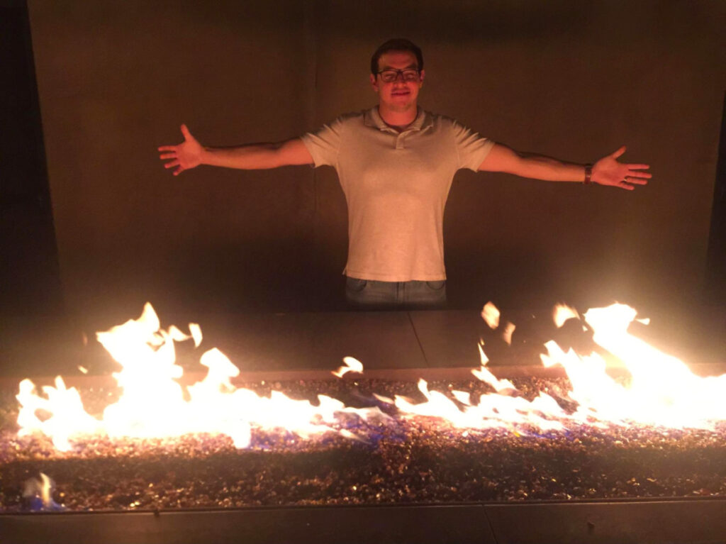 Author Jess Levy's cousin warming up by the outside fireplace at Shelter Encinitas