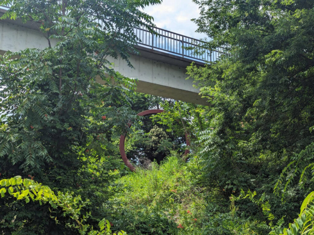 An art installments peaking through the lush greenery in the Floodwall Park