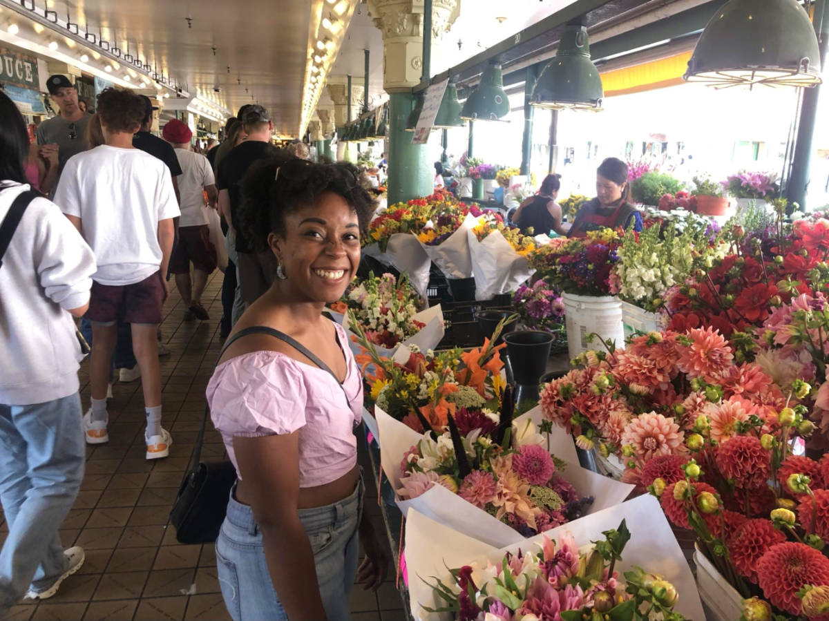 Author Chelsea Booker trying to choose between the flower bouquets at Pike Place Market