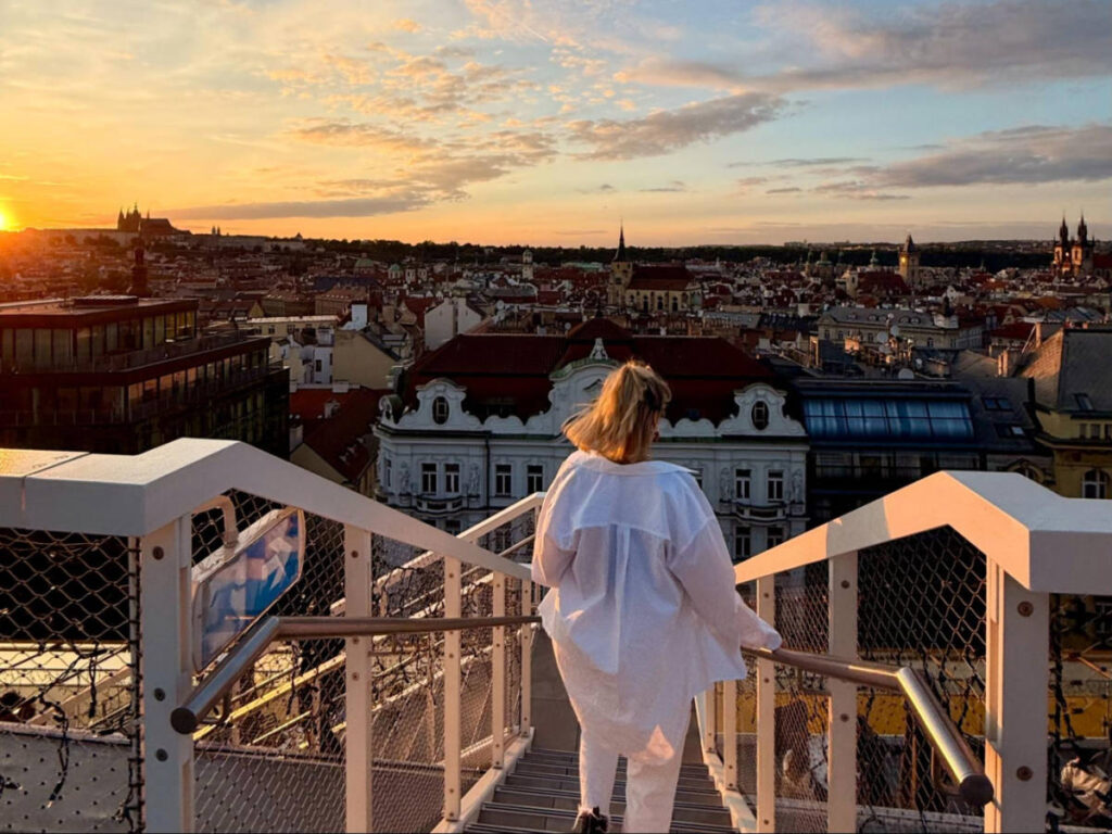 A woman going down the stairs at Fly Vista during sunset