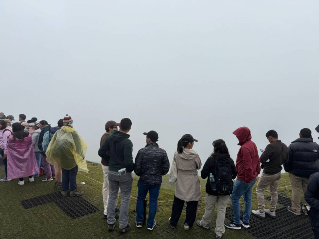 The crowd at the viewpoint with a foggy Machu Picchu