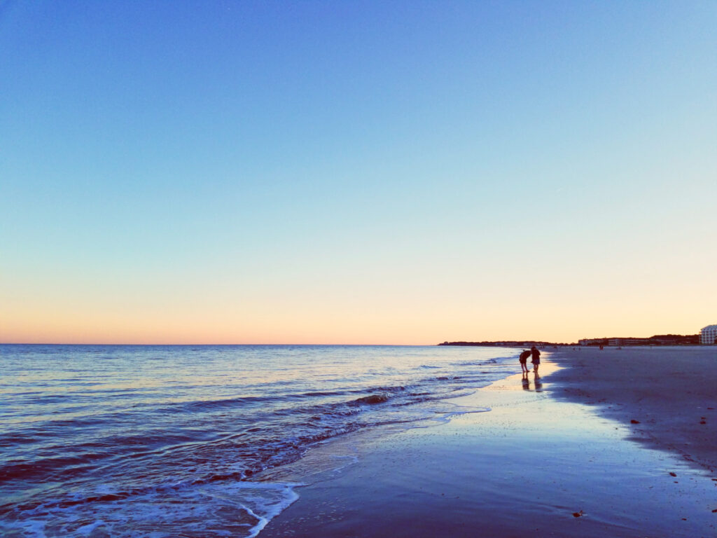 Couple strolling on Folly Field Beach Park at sunset