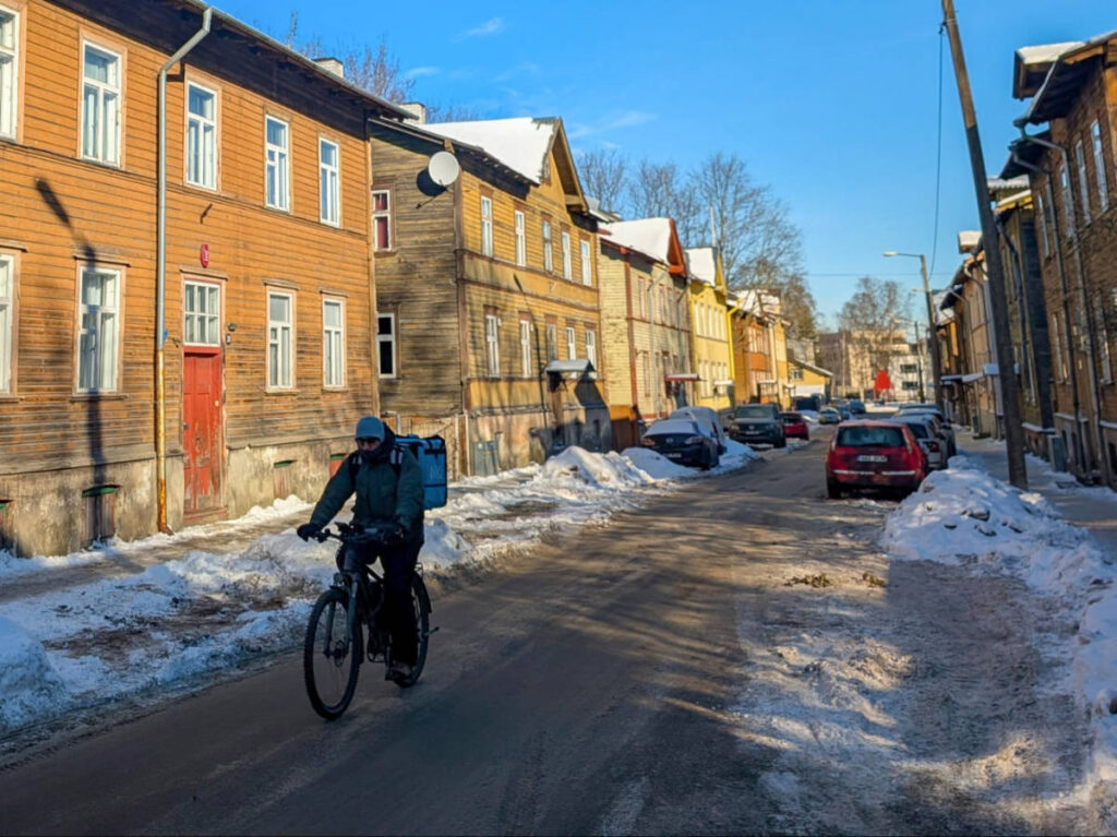 A food delivery driver cycles along the Kalamaja district