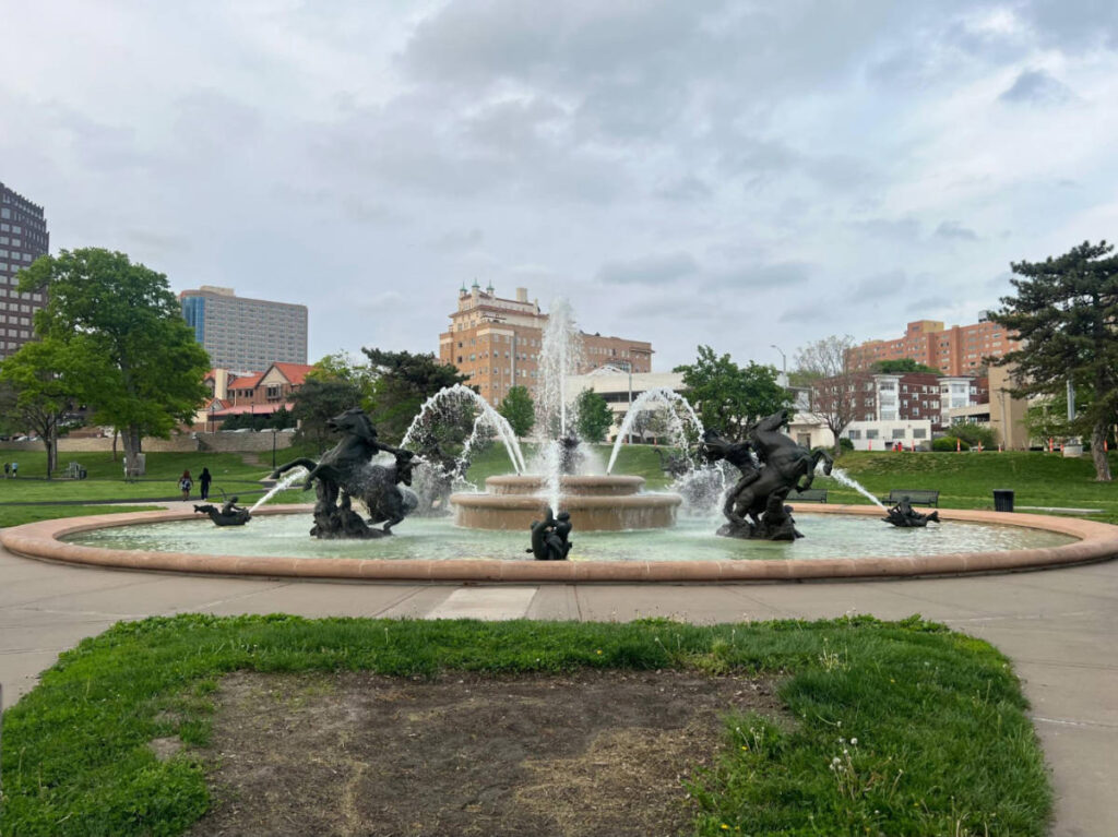 A fountain in Mill Creek Park with skyline views in the background