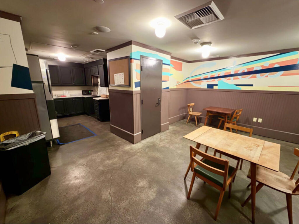 View of the basement lounge with a small kitchen in the Freehand Hotel