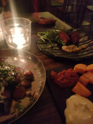 Plates of Fried chorizo, red onions, patatas bravas at Cubatas