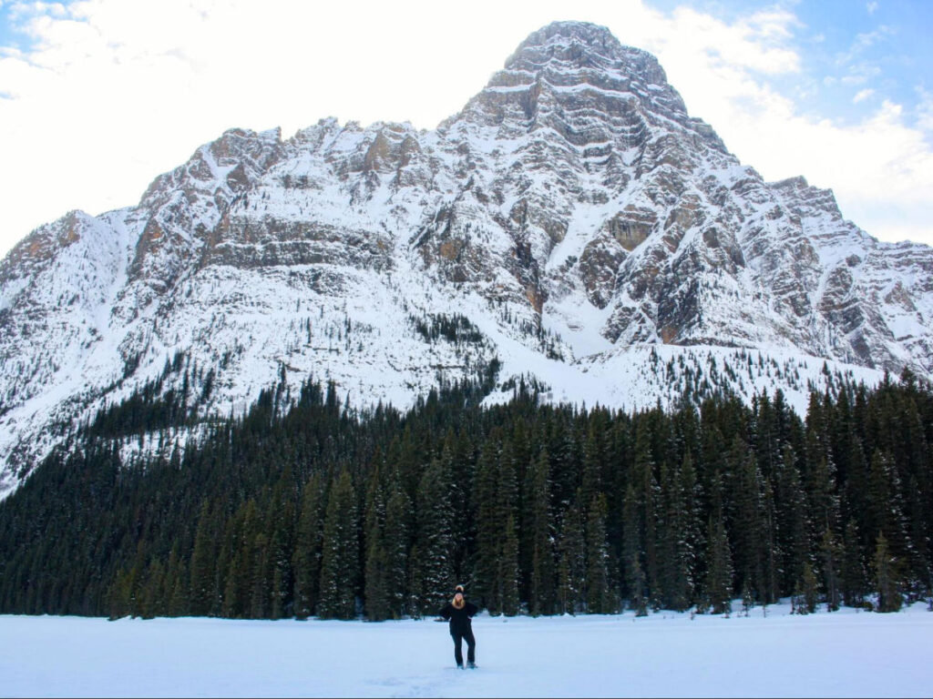 Author Taylor looking at the icy mountain while standing at the Frozen lake in Banff