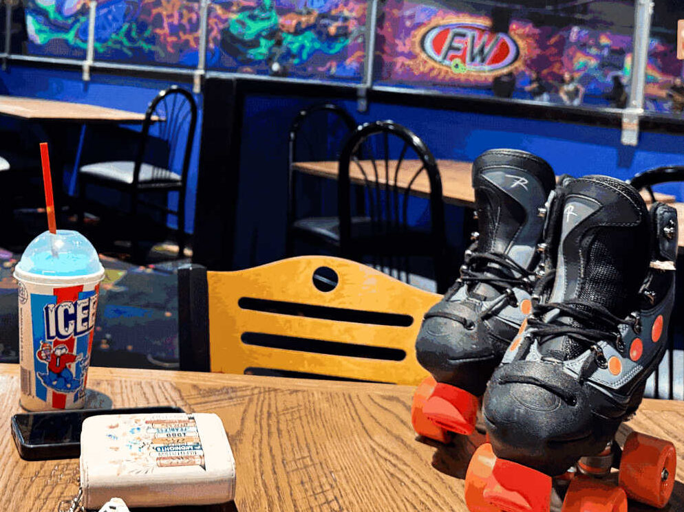 A drink and the roller blades on the table at the Fun Warehouse Roller Skating