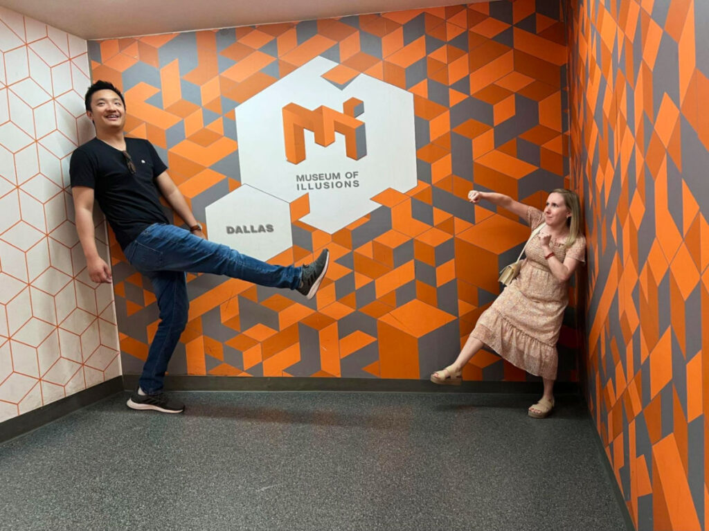 Couple having fun in front of a patterned wall at the Museum of Illusions