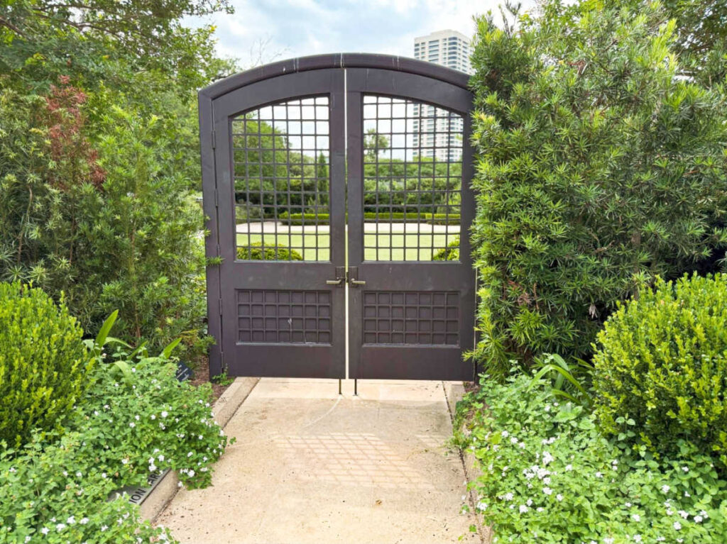 A metal gate surrounded by greenery at the McGovern Centennial Gardens