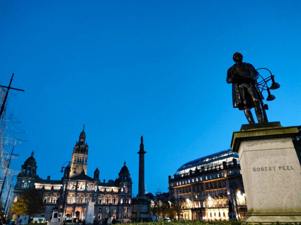 A statue and the City Chambers at the George Square in Glasgow