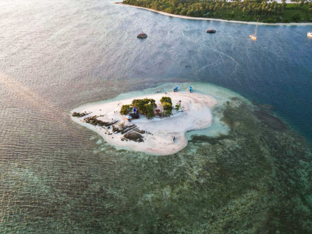 Aerial view of the small island of Gili Kedis surrounded by white sand and clear water