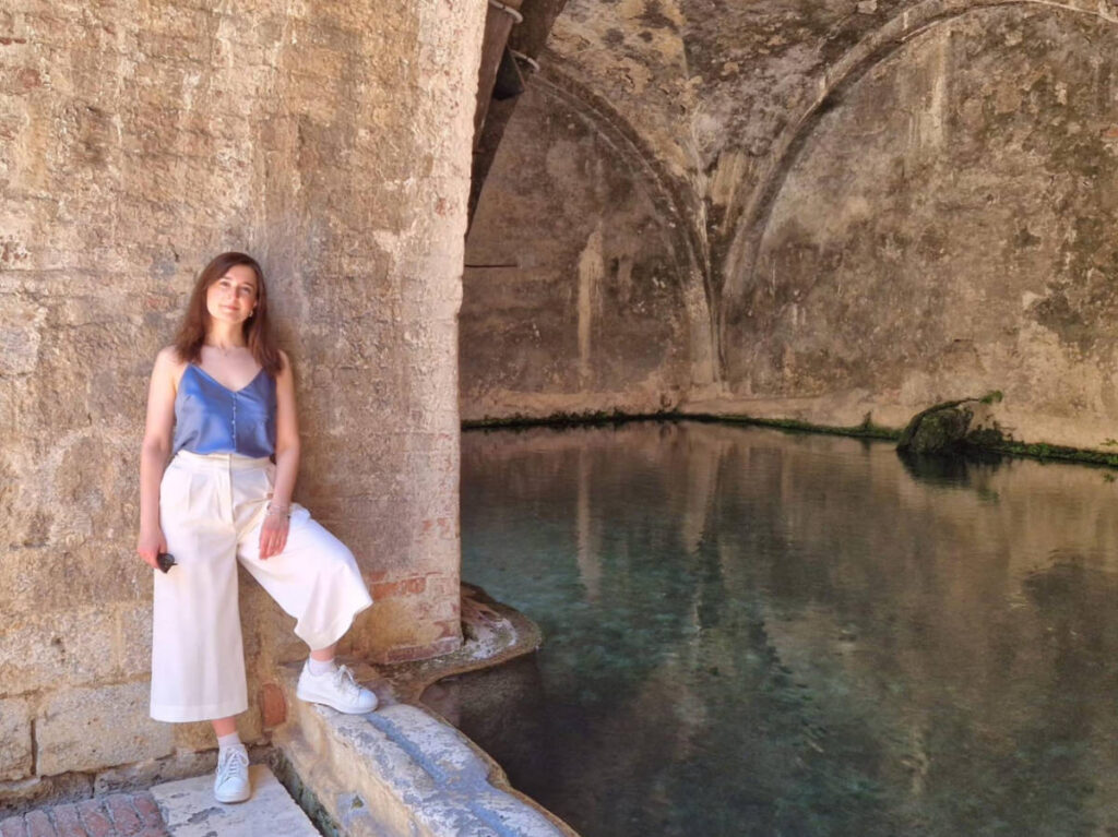 The author Giorgia Giustolisi, standing near the Fontebranda