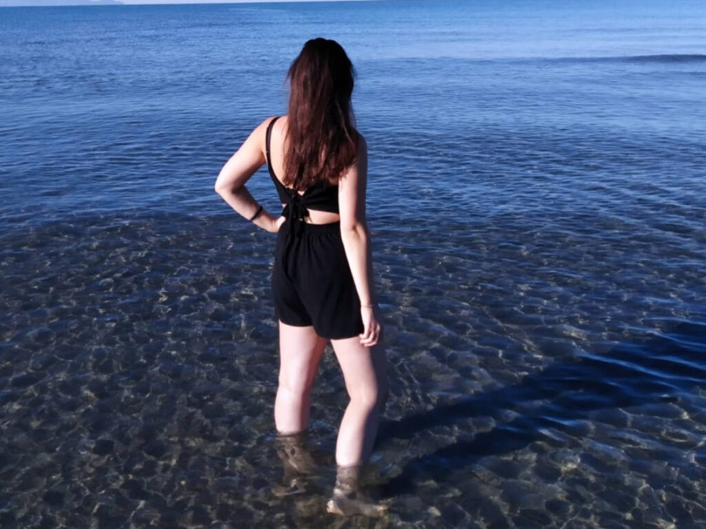 The author Giorgia Giustolisi, standing on the water in Marina di Alberese Beach