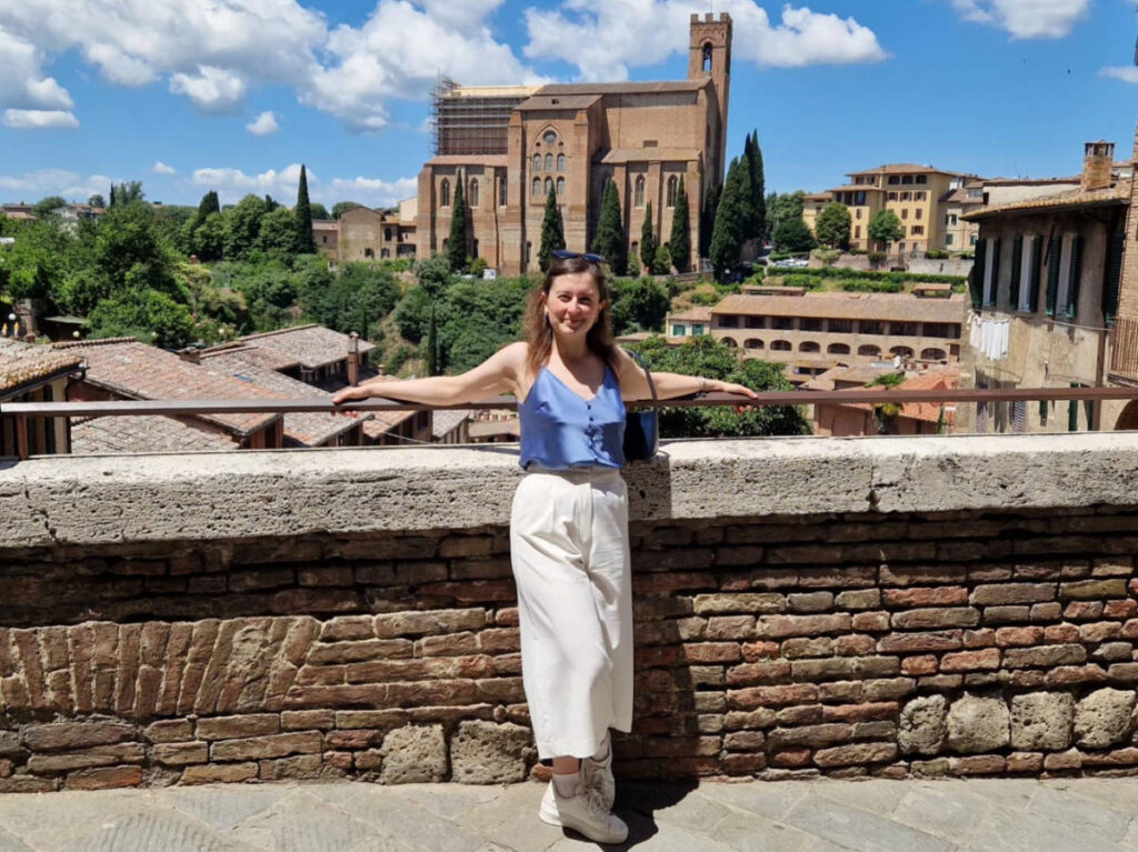 The author Giorgia Giustolisi, posing for a photo with the view of Basilica di San Domenico from Diacceto