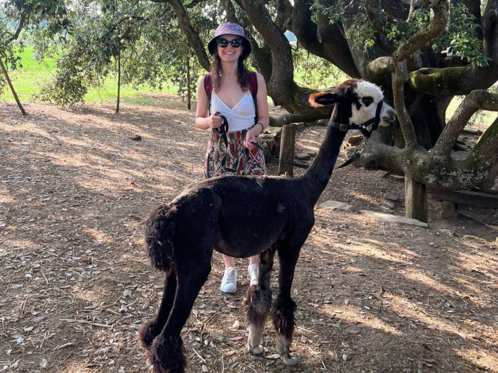 The author Giorgia Giustolisi, holding the leash of an alpaca in Fattoria Casabianca