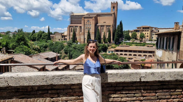 The author Giorgia Giustolisi, posing for a photo with the view of the Basilica di San Domenico from Diacceto