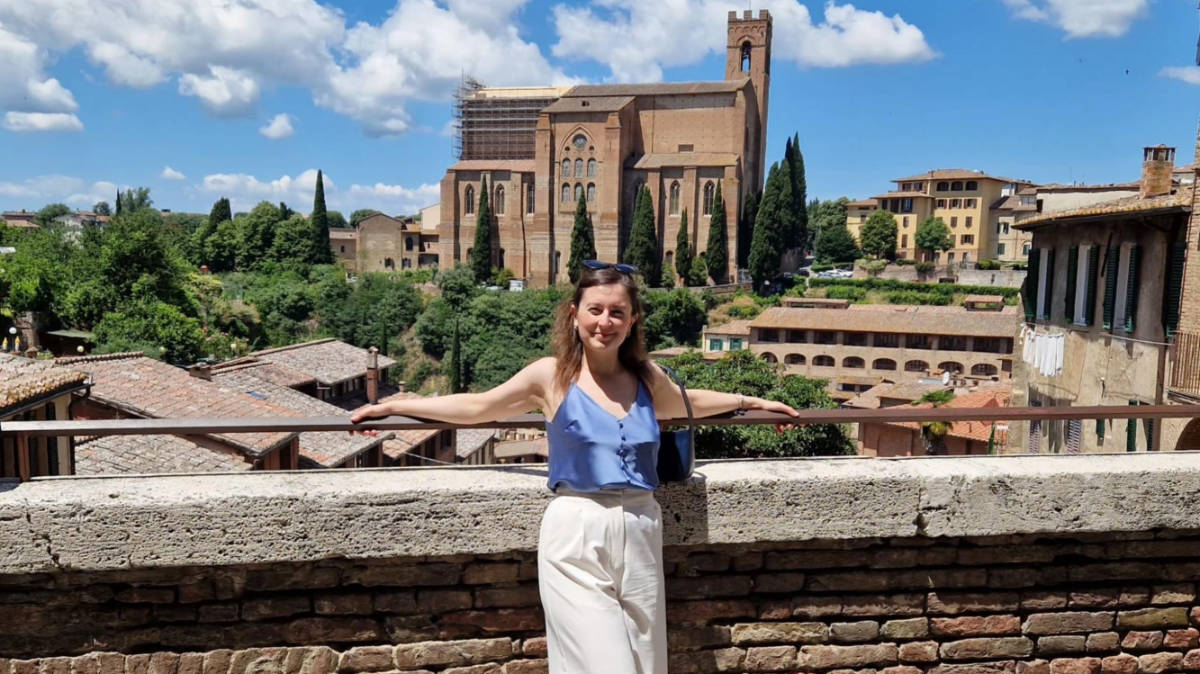 The author Giorgia Giustolisi, posing for a photo with the view of the Basilica di San Domenico from Diacceto