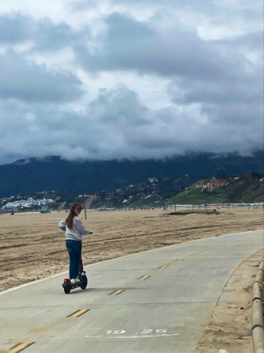 A girl riding the scooter in Santa Monica